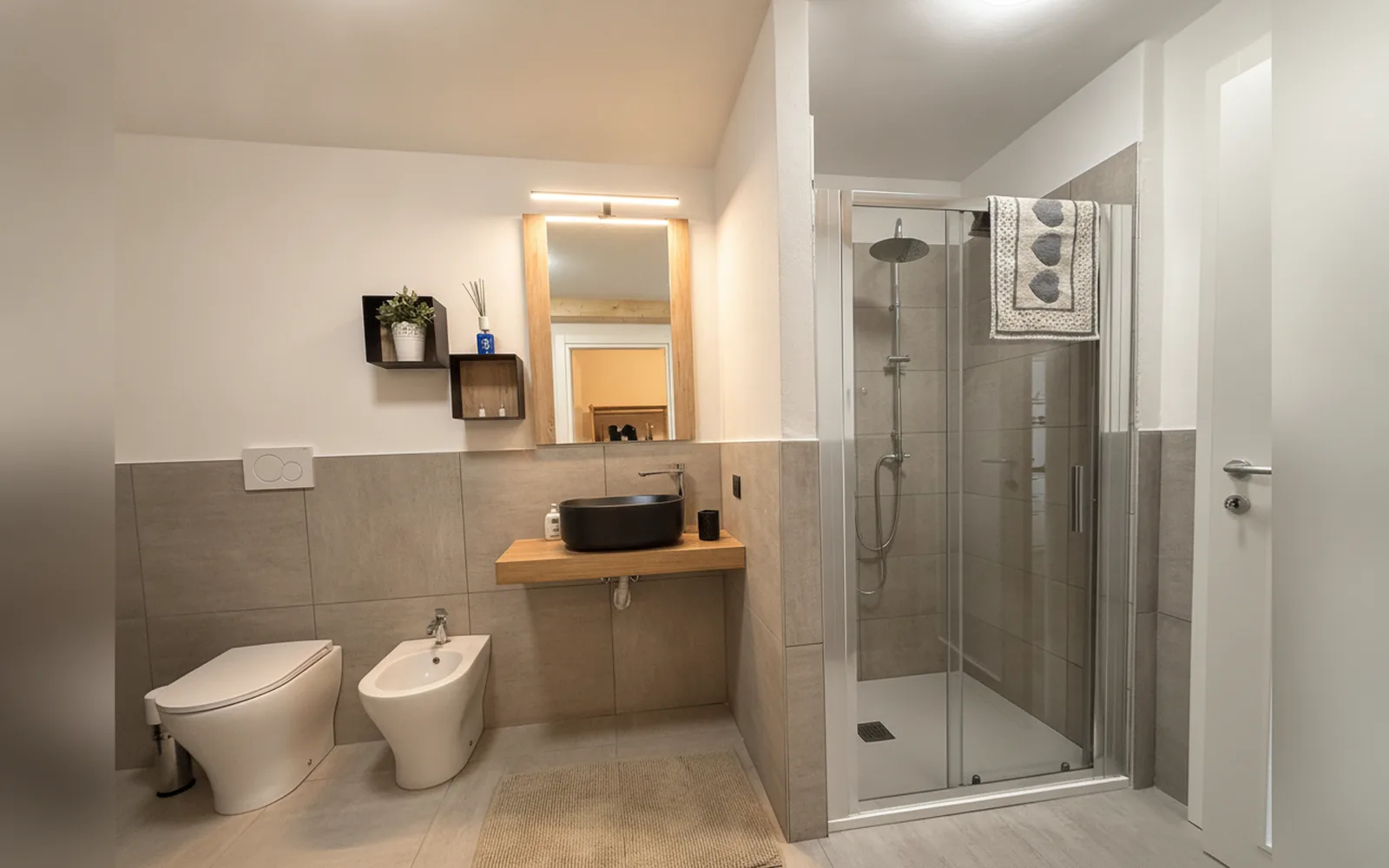 Bad mit Regendusche, schwarzem Aufsatzwaschbecken und Bidet