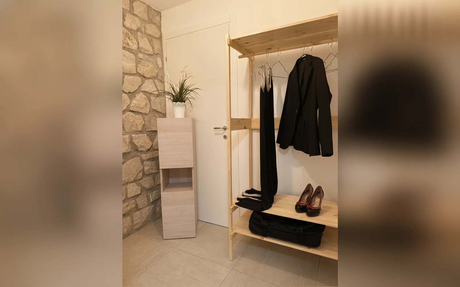 An open wardrobe beside the exposed stone wall